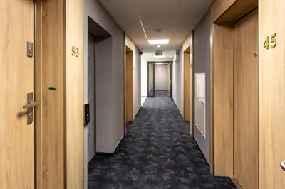 a hallway of an office building with a long corridor at Aparts Near Main Station in Kraków