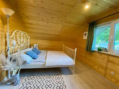 a bedroom with a bed in a wooden room at Domek w borówkach in Tokarnia