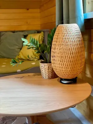 a table with a wicker lamp on top of it at Domek w borówkach in Tokarnia