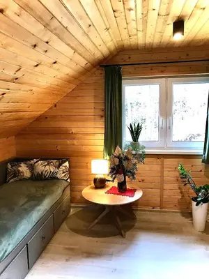a room with a bed and a table in it at Domek w borówkach in Tokarnia