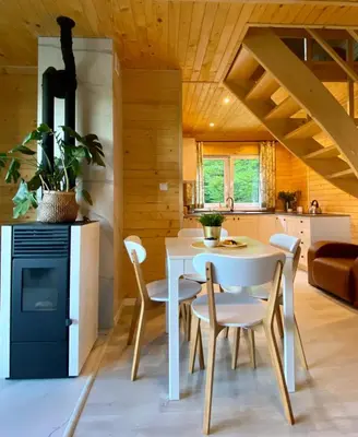 a kitchen and dining room with a white table and chairs at Domek w borówkach in Tokarnia