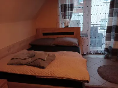 two beds in a room with a window at Uroczy apartament in Kraków