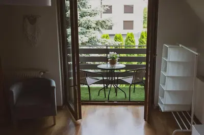 a glass door leading to a balcony with a table at Dom Marika - Energylandia Zator in Zator