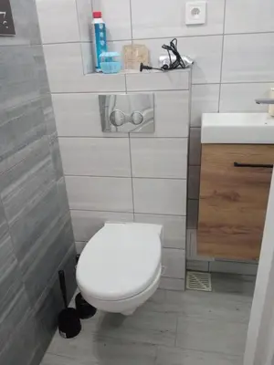 a bathroom with a white toilet and a sink at Uroczy Apartament in Kraków