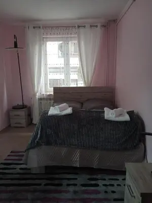 a bedroom with a bed with two towels on it at Uroczy Apartament in Kraków