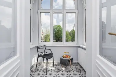 a room with a chair and a table and windows at Traveler's Best Choice - Old Town Guesthouse - by Upstairs in Kraków