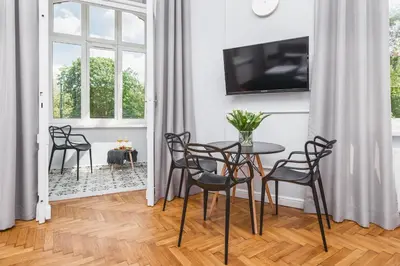 a dining room with a table and chairs and a tv at Traveler's Best Choice - Old Town Guesthouse - by Upstairs in Kraków