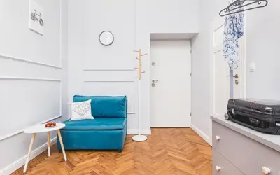 a living room with a blue chair and a table at Traveler's Best Choice - Old Town Guesthouse - by Upstairs in Kraków