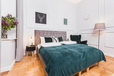 a bedroom with a bed with a green blanket at Traveler's Best Choice - Old Town Guesthouse - by Upstairs in Kraków