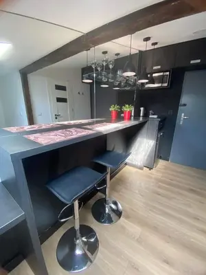 a kitchen with a bar with two stools in it at Jack Apartment in Old Town in Kraków