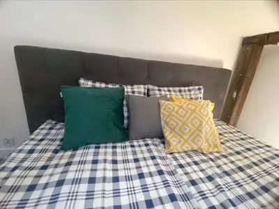 a bed with a blue and white checked sheets and pillows at Jack Apartment in Old Town in Kraków