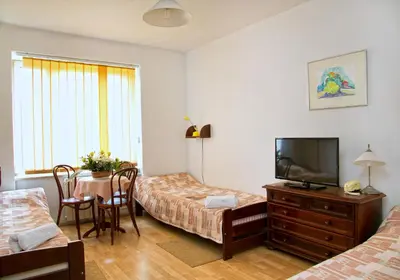 a bedroom with two beds and a table with a tv at Hotel Monttis in Sucha Beskidzka