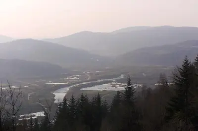 a view of a river in a valley with mountains at Hotel Monttis in Sucha Beskidzka