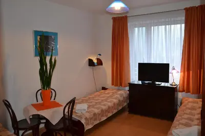 a hotel room with a bed and a tv and a table at Hotel Monttis in Sucha Beskidzka
