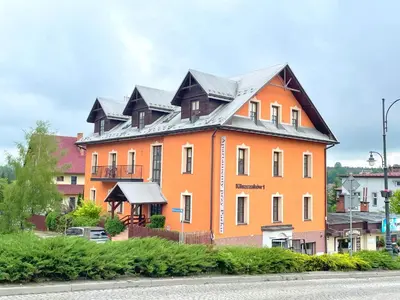 a bedroom with a bed and a kitchen with a table at Apartamenty Przy Parku in Rabka