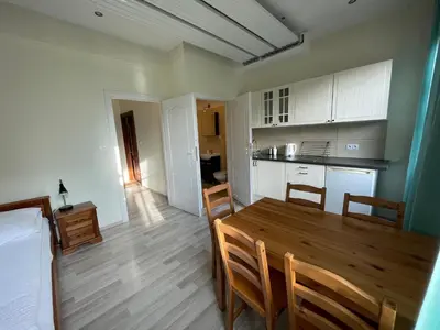 a bedroom with a bed and a kitchen with a table at Apartamenty Przy Parku in Rabka