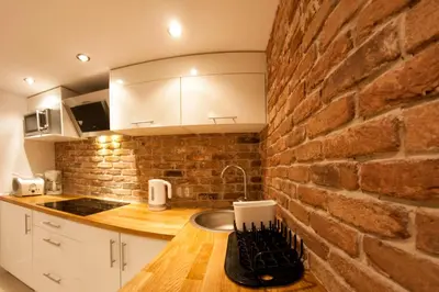 a kitchen with a brick wall and a counter at Kasia&Lukasz Apartments in Kraków