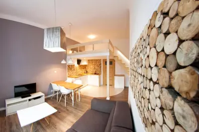 a living room and dining room with a large log wall at Kasia&Lukasz Apartments in Kraków