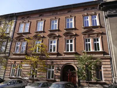 a brick building with cars parked in front of it at Kasia&Lukasz Apartments in Kraków