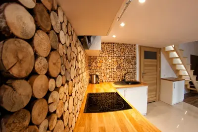a kitchen with a large wall of logs at Kasia&Lukasz Apartments in Kraków