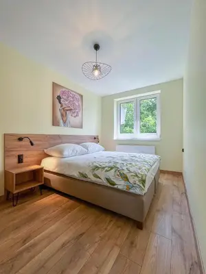 a bedroom with a large bed and a window at Apartament Ptasi Śpiew in Rabka