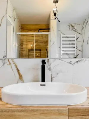 a bathroom with a white sink and a mirror at Apartament Ptasi Śpiew in Rabka