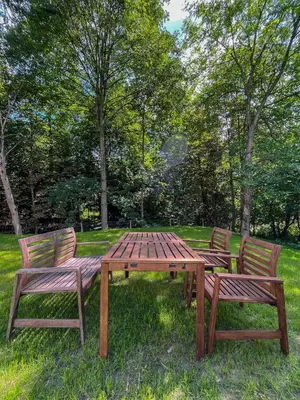 a wooden picnic table and two chairs in a park at Apartament Ptasi Śpiew in Rabka
