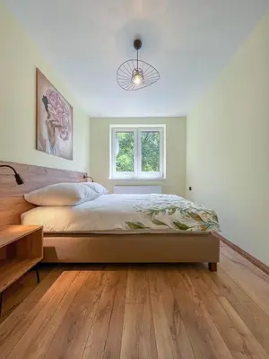 a bedroom with a large bed and a window at Apartament Ptasi Śpiew in Rabka
