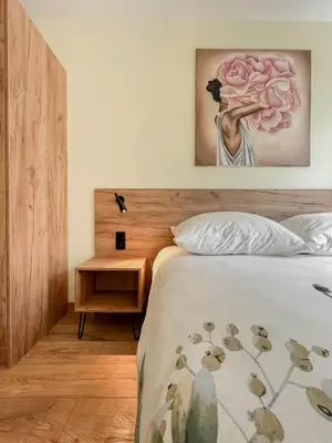 a bedroom with a bed with a painting on the wall at Apartament Ptasi Śpiew in Rabka