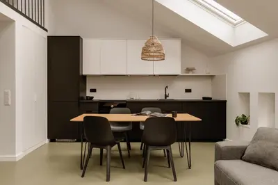a kitchen and dining room with a table and chairs at PLANTONIA Aparthotel in Kraków