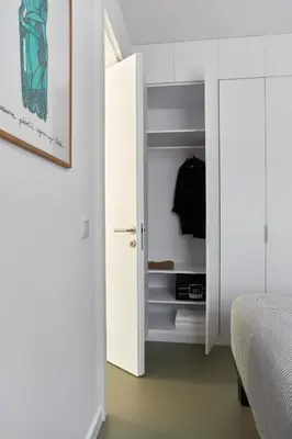 a bedroom with a white door and a closet at PLANTONIA Aparthotel in Kraków