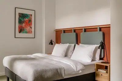 a bedroom with a large bed with white pillows at PLANTONIA Aparthotel in Kraków
