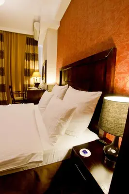 a bedroom with a bed with white sheets and pillows at Hotel Columbus in Kraków