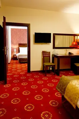 a hotel room with a bedroom with a bed and a desk at Hotel Columbus in Kraków