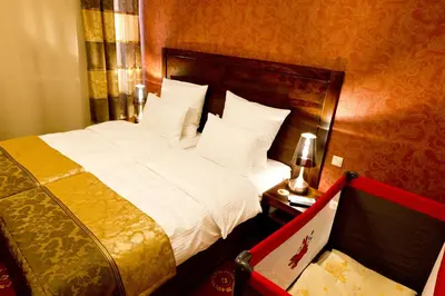 a bedroom with a large bed with white sheets and pillows at Hotel Columbus in Kraków