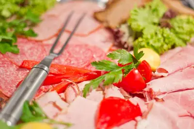a plate of meat and vegetables with a knife and fork at Hotel Columbus in Kraków