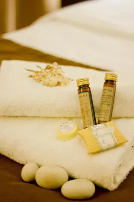 a pile of towels with two bottles of essential oils at Hotel Columbus in Kraków
