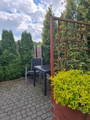 a table and a chair sitting on a patio at Mieszkanie A Łowiczki in Zator