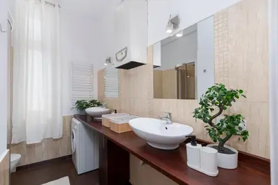 a bathroom with two sinks and a large mirror at Brzozowa Apartments by Hostly in Kraków