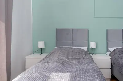 a bedroom with two beds and two lamps at Brzozowa Apartments by Hostly in Kraków