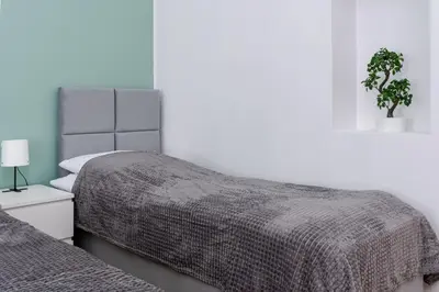 a bedroom with two beds and a potted plant at Brzozowa Apartments by Hostly in Kraków