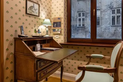 an old wooden desk in a room with a chair at Hotel Gródek in Kraków