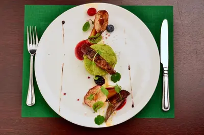 a white plate with some food on a table at Hotel Gródek in Kraków