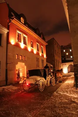 a horse drawn carriage parked in front of a building at Hotel Gródek in Kraków