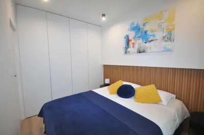 a bedroom with a bed with yellow and blue pillows at Krakowskie Malediwy by JoApart - Tauron Arena, Expo in Kraków