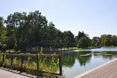 a view of a lake with a building next to it at Krakowskie Malediwy by JoApart - Tauron Arena, Expo in Kraków