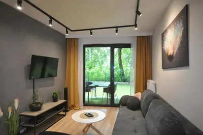 a living room with a couch and a table at Krakowskie Malediwy by JoApart - Tauron Arena, Expo in Kraków
