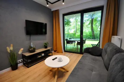 a living room with a couch and a table at Krakowskie Malediwy by JoApart - Tauron Arena, Expo in Kraków