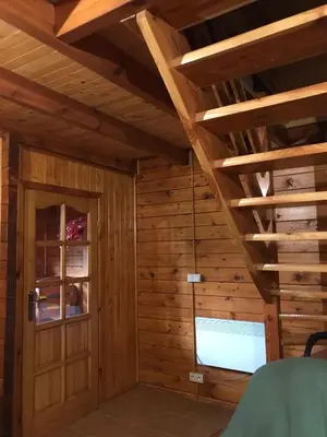 a room with wooden walls and a ceiling with wooden beams at Domek letniskowy Biedówka in Limanowa