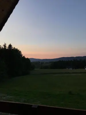 a view from a window of a field at sunset at Domek letniskowy Biedówka in Limanowa